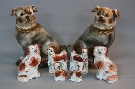 A PAIR OF LATE 19TH CENTURY POTTERY FIGURES OF SEATED PUGS, glass eyes, gilt collars and gilt detail