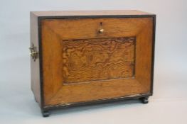 AN EDWARDIAN OAK STATIONERY BOX, fitted with brass carrying handles, the fall front opening to