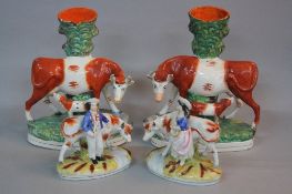 A PAIR OF VICTORIAN STAFFORDSHIRE POTTERY SPILL VASES, in the form of a Cow and Suckling Calf by a