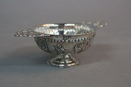 A 19TH CENTURY CONTINENTAL SILVER WINE TASTER, with cast foliate and mask handles, the circular body