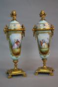 A PAIR OF LATE 19TH CENTURY ORMOLU AND CONTINENTAL PORCELAIN GARNITURES, of urn form, winged bust