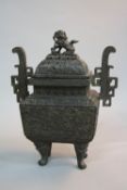 AN ORIENTAL BRONZE KORO, of rectangular form, dog of fo finial above domed cover, cast with