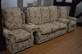 A FLORAL UPHOLSTERED THREE PIECE LOUNGE SUITE, comprising of a three seater settee and a pair of