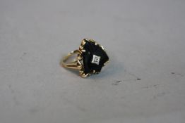 A MID TO LATE 20TH CENTURY ONYX AND DIAMOND RING, shield shape, centering on an eight cut diamond