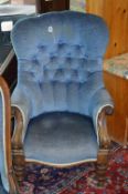 A VICTORIAN CARVED WALNUT BUTTONBACK ARMCHAIR, with foliate scrolls and blue upholstery