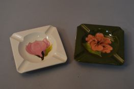 TWO MOORCROFT POTTERY ASH TRAYS, 'Magnolia' on cream ground and 'Hibiscus' on green ground, both