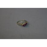 A 9CT RUBY AND DIAMOND CROSS OVER RING, size J