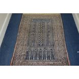 A 20TH CENTURY PERSIAN WOOL RUG, multi strap border, and faded red, black ground and geometric