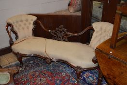 A VICTORIAN CARVED MAHOGANY SOFA, with carved foliate design centrally to button back, scrolled arms