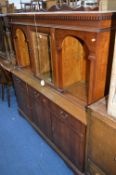 A MAHOGANY WALL UNIT, with bevelled glass centre and two open shelves to top, three drawers and