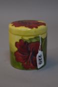 A MOORCROFT POTTERY COVERED POT, 'Hibiscus'pattern on green/yellow ground, impressed mark to base,