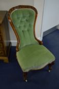 A VICTORIAN WALNUT SPOON BACK CHAIR, with buttoned green upholstery and carved top rail