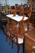 A MODERN MAHOGANY PEDESTAL DROP LEAF TABLE and six chairs with drop in seat pads including two