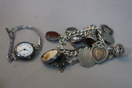 A SILVER CHARM BRACELET, with various charms, fobs, etc, together with a S W R ladies watch