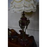 A PAIR OF REGENCY STYLE TABLE LAMPS, a gilt metal and claret glazed ceramic bases, goats head