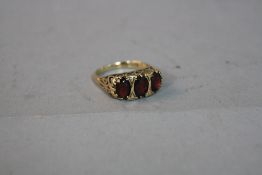 A 9CT GARNET THREE STONE RING, ring size Q, approximate weight 3.8 grams