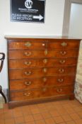 A GEORGE III OAK CHEST, of two short and five long graduated drawers with brass escutcheons and