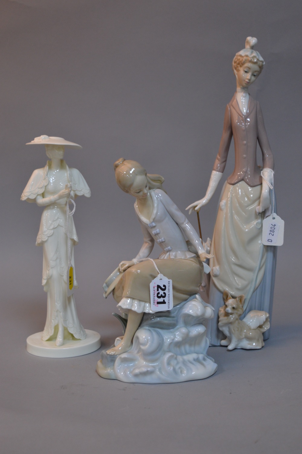 TWO LLADRO FIGURES, seated girl on rock by water and fish and a lady with parasol and dog,