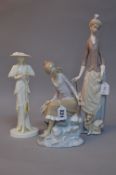 TWO LLADRO FIGURES, seated girl on rock by water and fish and a lady with parasol and dog,