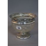 AN EDWARDIAN SILVER AND CUT GLASS BOWL, silver rim embossed with floral swags, fluted circular foot,