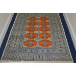 A 20TH CENTURY PERSIAN WOOL RUG, multi strap border, surrounding a rust colour ground with geometric