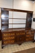 A GEORGE III OAK AND MAHOGANY BANDED DRESSER BASE, fitted with an arrangement of seven drawers