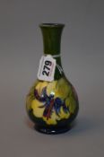 A MOORCROFT POTTERY BUD VASE, Hibiscus pattern on green ground, paper label to base, approximate
