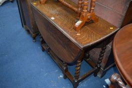 AN OAK BARLEY TWIST GATE LEG TABLE