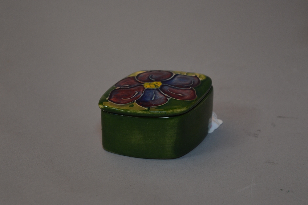 A SMALL MOORCROFT POTTERY TRINKET POT, clematis pattern, paper label underside of lid and