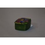 A SMALL MOORCROFT POTTERY TRINKET POT, clematis pattern, paper label underside of lid and