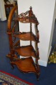 A VICTORIAN WALNUT FOUR TIER CORNER SERPENTINE FRONTED WHATNOT, fret cut gallery to top tier, the