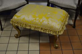 A VICTORIAN RECTANGULAR STOOL, with gold upholstered and tassle fringe on a later painted gilt