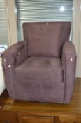 A PURPLE UPHOLSTERED SWIVEL/ROCKING ARMCHAIR