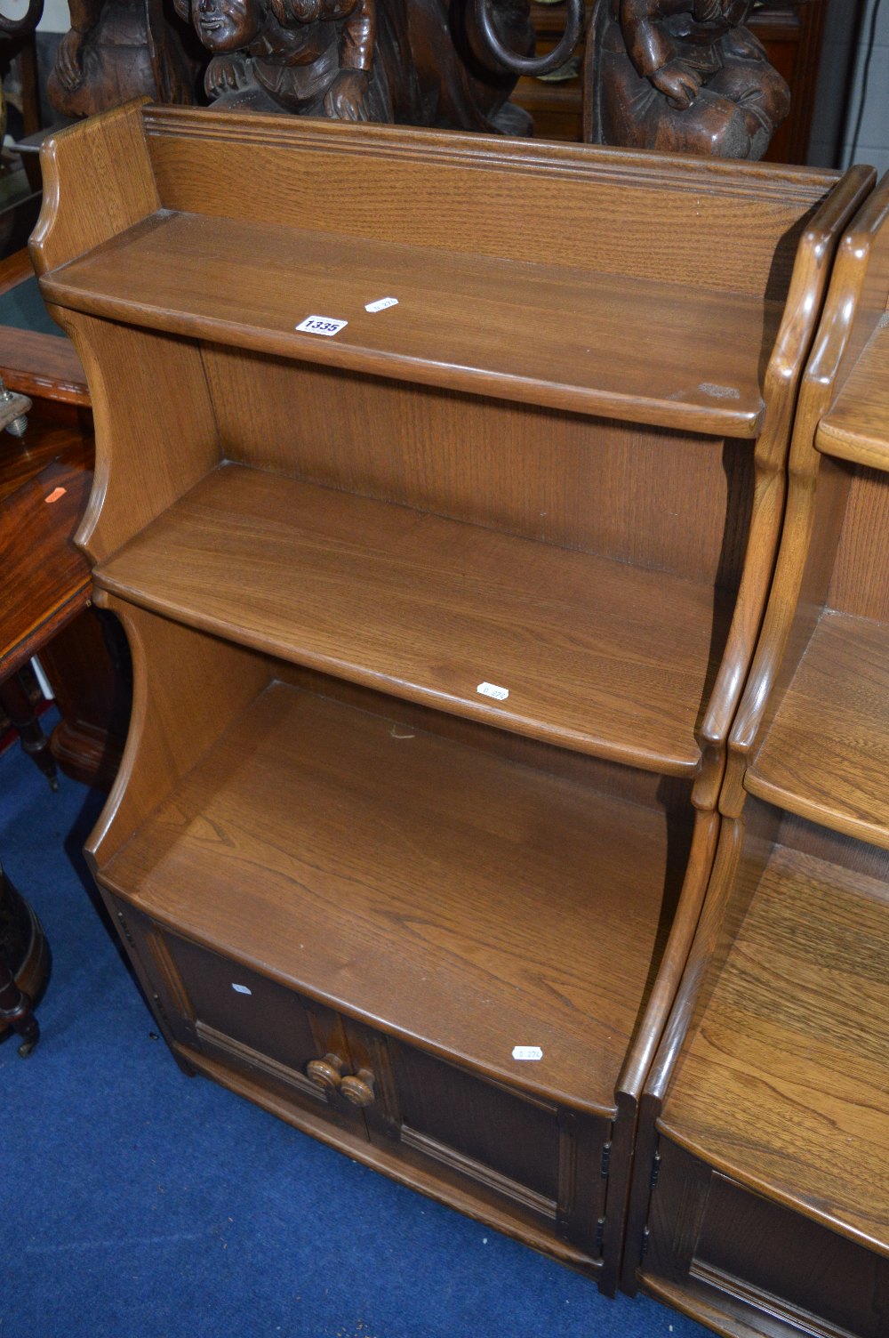 AN ERCOL ASH CASCADE BOOKCASE, with two tier shelving above double cupboard base