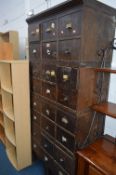 AN EARLY 20TH CENTURY STAINED OAK OFFICE DRAWERS, made up of twenty four drawers with various