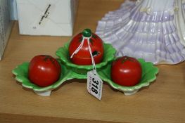 A CARLTONWARE NOVELTY CRUET SET AND STAND, shaped as tomatoes in leaves