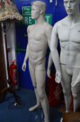 A FULL LENGTH MALE SHOP DISPLAY MANNEQUIN, on a seperate glass stand, approximate height 182cm