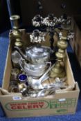 A BOX OF SILVER PLATE, including a three piece tea set, pair of brass candlesticks, soup ladle, etc