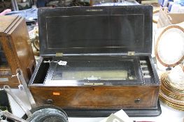 A VICTORIAN WALNUT AND EBONISED MUSIC BOX, mechanism defective, cylinder length 28cm