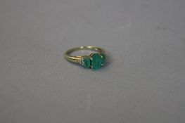 A 9CT THREE STONE EMERALD RING, with diamond shanks, ring size K, approximate weight 2.0 grams
