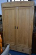 A PINE PANELLED DOUBLE DOOR WARDROBE, two drawers below, width 117cm