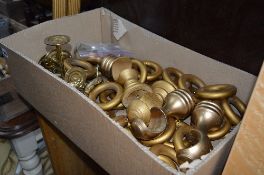 THREE GOLD COLOURED CURTAIN POLES, a box of rings and brackets and a set of gold curtains (s.d)