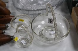 A SET OF THREE GRADUATED CIRCULAR GLASS BASKETS, with twisted handles