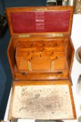 AN EDWARDIAN OAK FITTED STATIONARY BOX, with letter rack, fall front slope, pull-out ink wells and