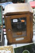 AN OAK SMOKERS CABINET, with ceamic tobacco jar, approximate height 32cm