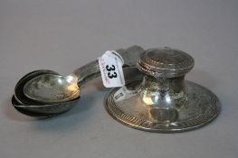 A SILVER CAPSTAN INKWELL, with five spoons