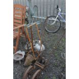 A VINTAGE CAST IRON PLOUGH, two metal stands, cast iron hopper, a weather vane, etc