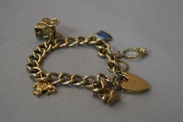 A 9CT GOLD CHARM BRACELET, approximate weight 24.6 grams
