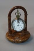 A SILVER POCKET WATCH, on a watch stand (key)