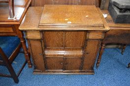 AN OAK SINGER TREADLE SEWING MACHINE, with rise and fall mechanism and various storage drawers,